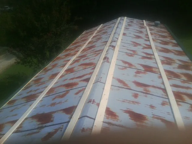 Rusted metal roof panels with new wood purlins before replacement — Storm Damage Roof Repair in Whitefish by Roofing Brothers