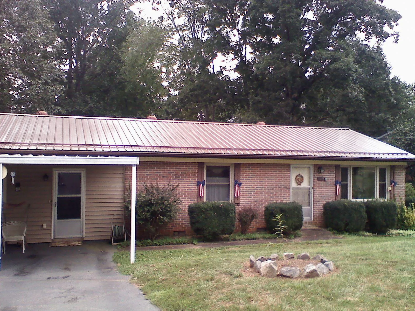 Bronze metal roof and carport on a brick ranch home — Roof Repair work by our crew in Whitefish